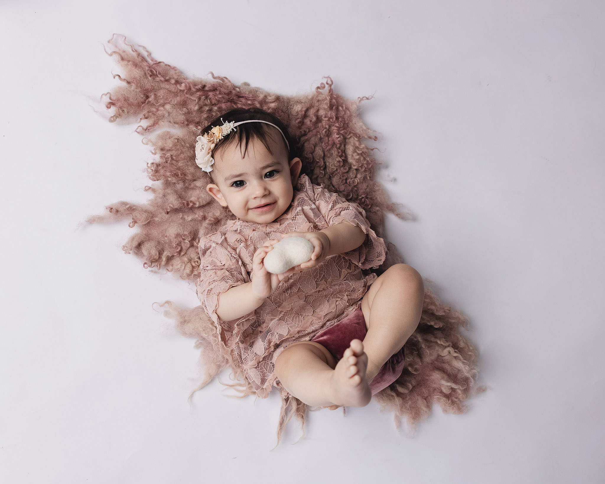 Smiling toddler sitting on studio floor during toddler studio photos Pittsburgh