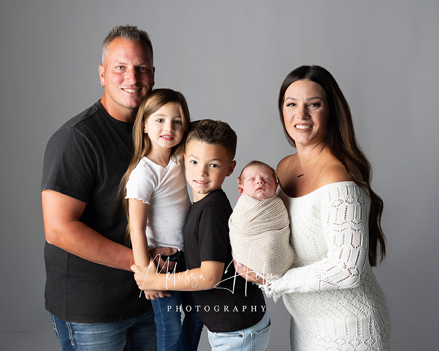 Family of five posing during studio newborn photography session in Pittsburgh