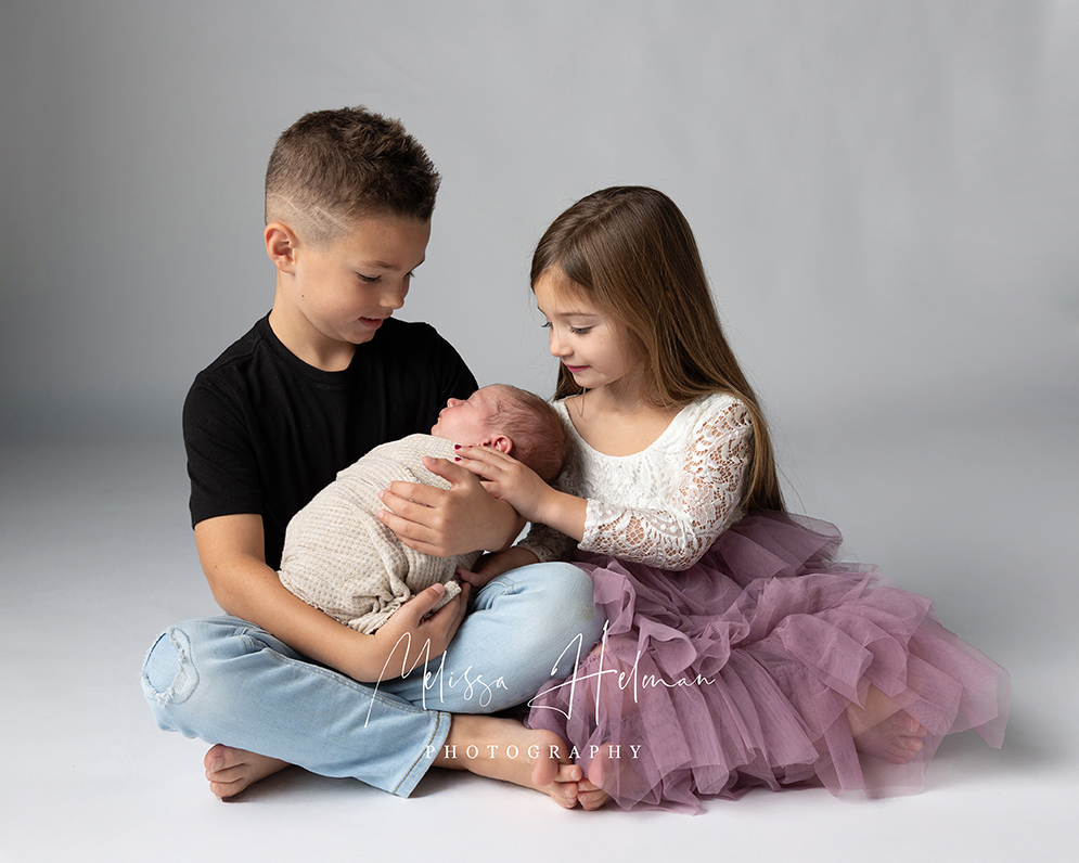 Three siblings during a newborn session in Pittsburgh, with baby number three in the center