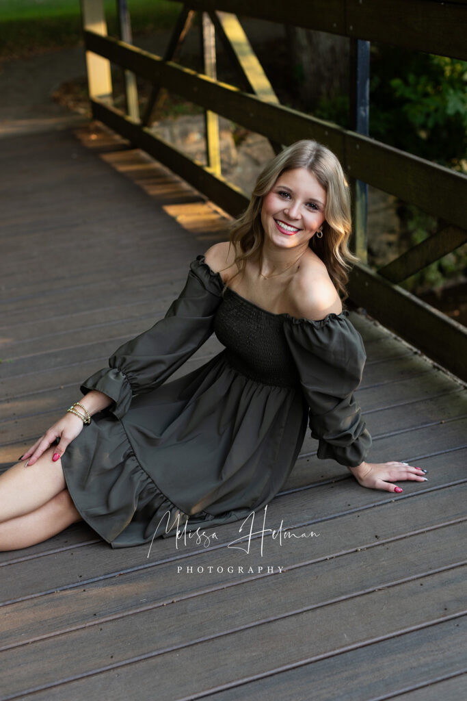 Senior girl walking along a tree-lined path at University of Pittsburgh Greensburg during senior photo session