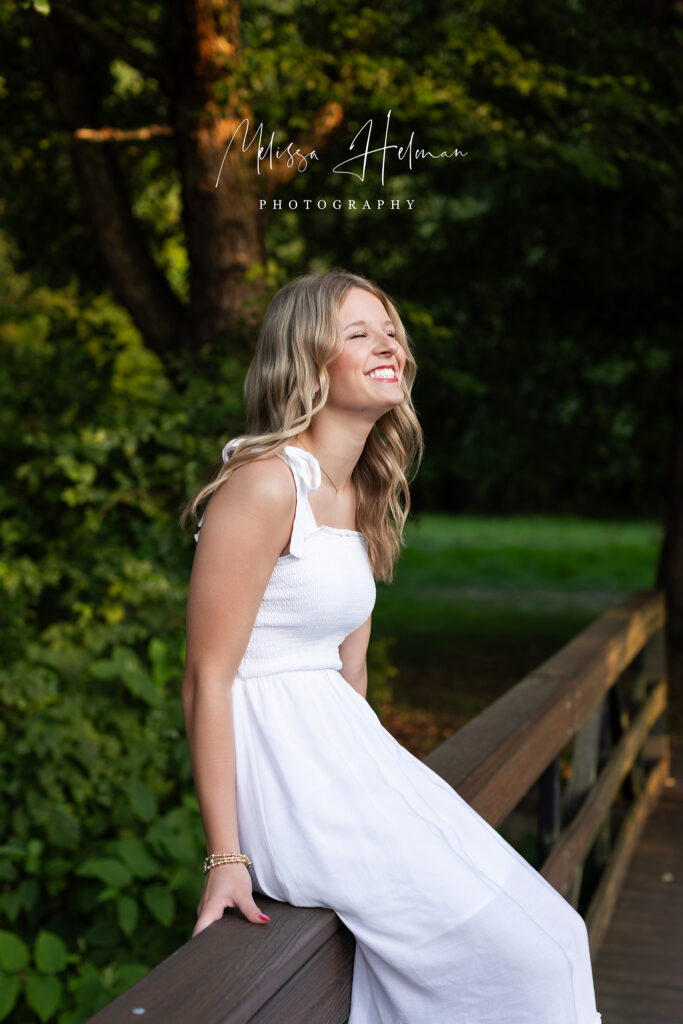 Senior girl laughing on bridge at  University of Pittsburgh Greensburg during senior photo session
