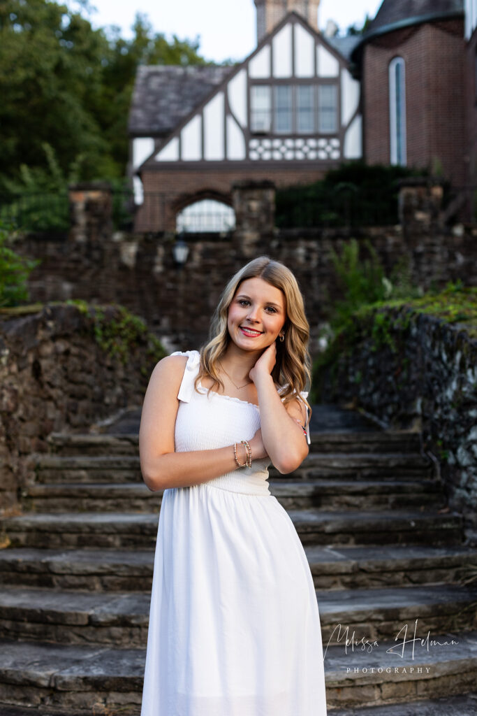 Pittsburgh senior posing naturally on a stone bench surrounded by greenery at UPG
