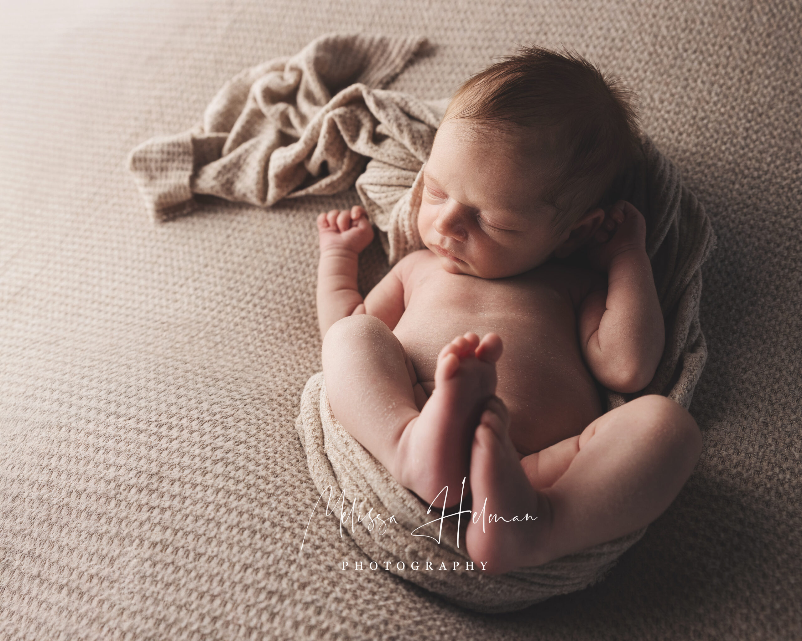 Newborn baby sleeping in neutral wrap during Pittsburgh studio photography session