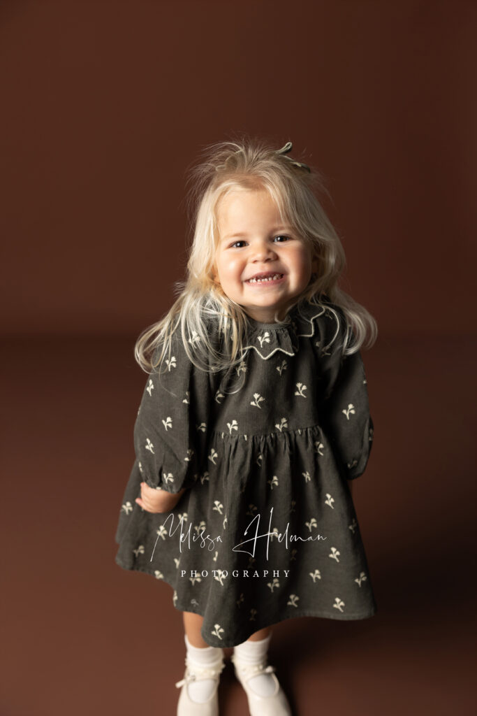 Girl in green Holiday dress standing for her picture with Melissa Helman Photography